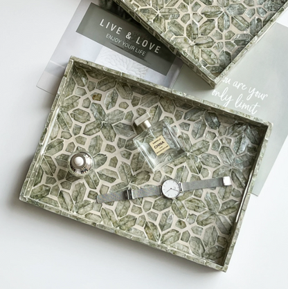 Gray green natural shell tray styled with perfume and watch